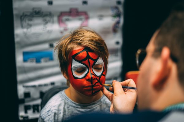 A child at a halloween event gets face paint.